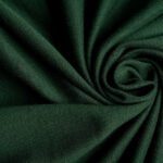 Dark green knitted fabric showing fine stitch texture and soft folds.