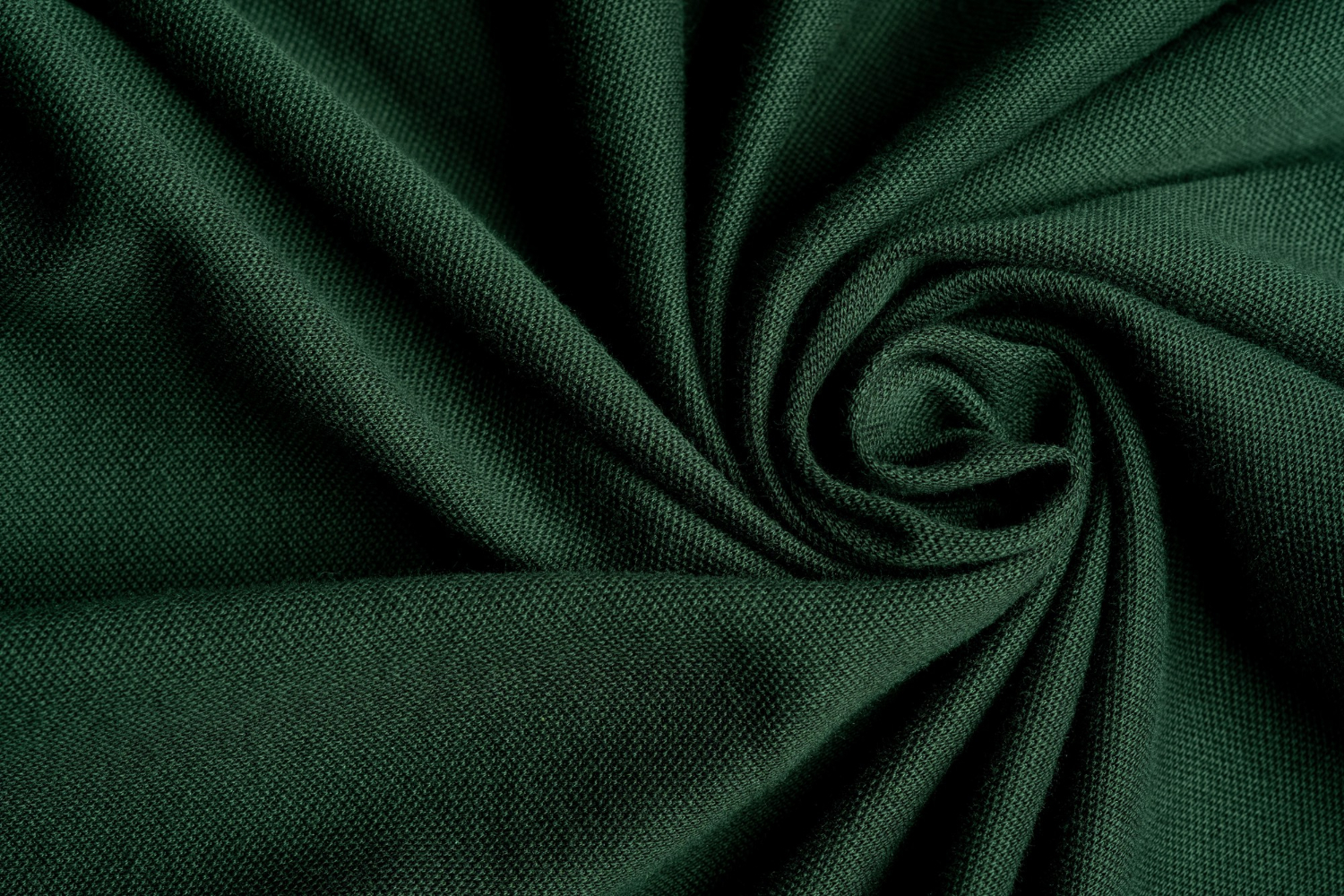 Dark green knitted fabric showing fine stitch texture and soft folds.